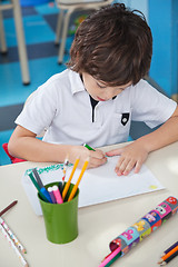 Image showing Little Boy Drawing At Desk In Art Class