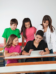 Image showing Teenage Friends Using Digital Tablet At Desk