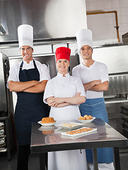 Image showing Confident Chefs With Sweet Dishes On Kitchen Counter