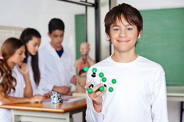 Image showing Teenage Schoolboy Holding Molecular Structure In Biology Class