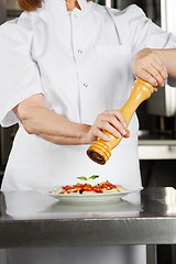 Image showing Female Chef Seasoning Dish With Pepper