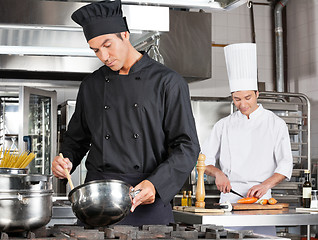 Image showing Chef Cooking Food With Colleague Chopping Vegetable