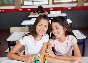 Image showing Schoolgirl Sitting With Female Friend In Classroom