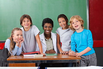 Image showing Happy Teacher With Students At Desk