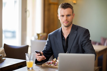 Image showing Young Business man With Mobilephone And Laptop In Coffeeshop