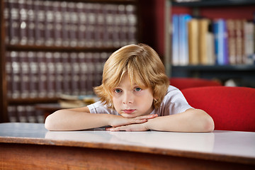 Image showing Bored Schoolboy Leaning On Table In Library