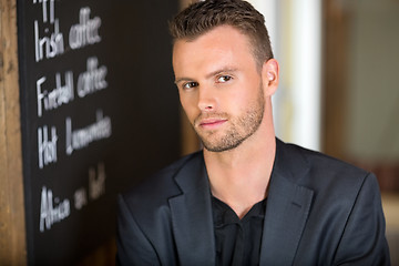 Image showing Businessman Next To Chalkboard At Coffeeshop