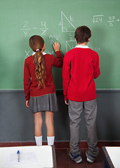 Image showing Teenage Schoolchildren Writing On Board