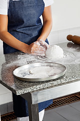 Image showing Female Chef Kneading Dough On Counter