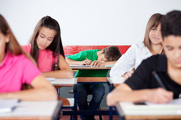 Image showing Male Student Sleeping On At Classroom