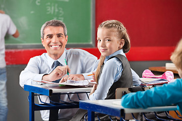 Image showing Girl And Teacher Sitting At Desk In Classroom