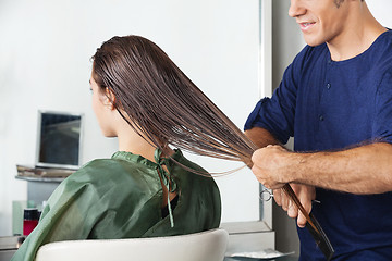 Image showing Male Hairdresser Combing Client's Wet Hair