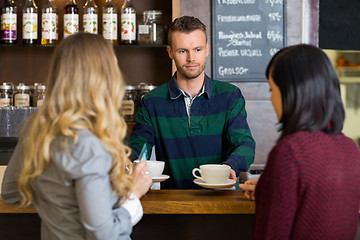 Image showing Bartender Serving Coffee To Women At Counter In Cafe