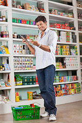 Image showing Man Checking Grocery List In Supermarket