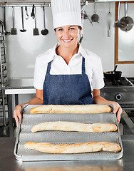 Image showing Female Chef Presenting Loafs In Kitchen