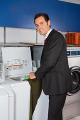 Image showing Businessman Washing Clothes At Laundromat