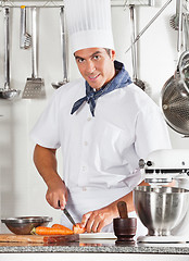 Image showing Young Male Chef Cutting Carrots