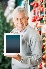 Image showing Man Displaying Digital Tablet In Christmas Store