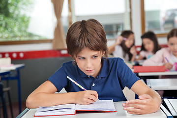 Image showing Schoolboy Cheating At Desk During Examination