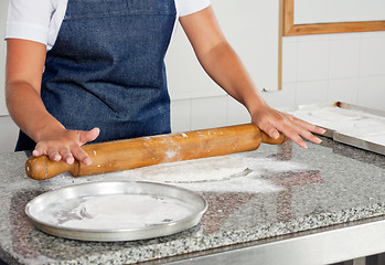 Image showing Female Chef Rolling Dough On Counter