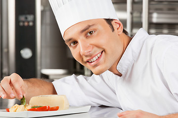 Image showing Happy Male Chef Garnishing Dish