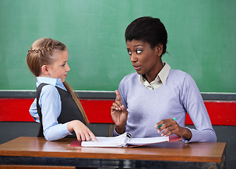 Image showing Female Teacher Scolding Schoolgirl At Desk