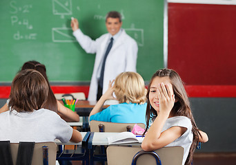 Image showing Girl Covering One Eye While Sitting At Desk