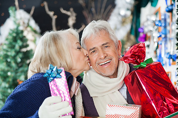 Image showing Senior Woman Kissing Man With Christmas Presents