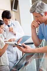 Image showing Doctor Reading Document At Reception