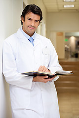 Image showing Mid Adult Doctor Holding Book