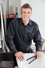 Image showing Happy Hairstylist Holding Straightener