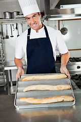 Image showing Male Chef Presenting Baked Loafs In Kitchen