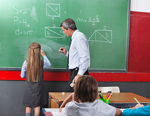 Image showing Girl Solving Mathematics On Board With Teacher