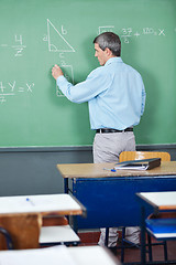 Image showing Professor Solving Mathematics On Greenboard In Classroom