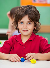 Image showing Little Boy With Clay At Desk