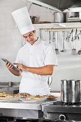 Image showing Chef Using Tablet With Pasta Dishes At Counter