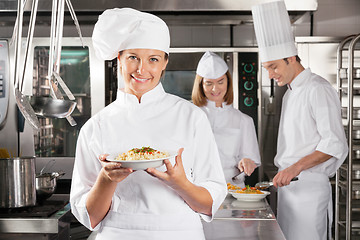 Image showing Happy Chef Presenting Dish In Industrial Kitchen