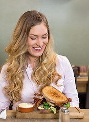 Image showing Woman Looking At Burger In Restaurant