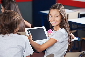 Image showing Schoolgirl Holding Digital Tablet At Desk