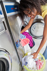 Image showing Woman Loading Dirty Clothes In Washing Machine