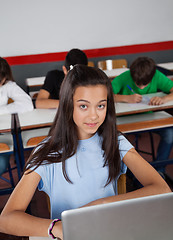 Image showing Pretty Teenage Schoolgirl Sitting With Laptop In Classroom