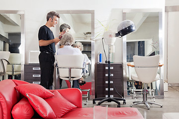 Image showing Hairstylist Straightening Client's Hair At Salon