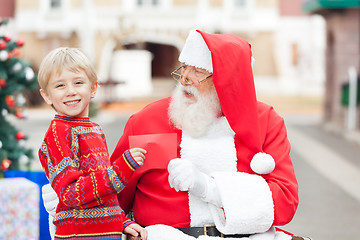 Image showing Happy Boy Giving Letter To Santa Claus