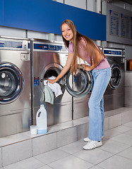 Image showing Woman Putting Clothes In Washing Machine