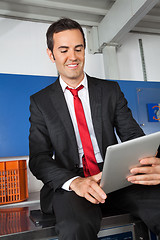 Image showing Businessman Using Digital Tablet In Laundry