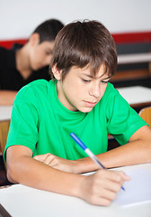 Image showing Teenage Schoolboy Writing At Desk During Examination