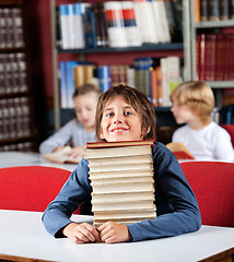 Image showing Schoolboy Resting Chin On Stack Of Books