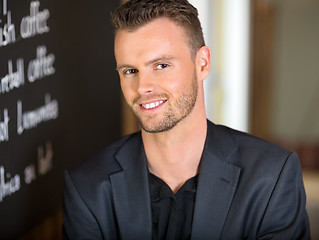 Image showing Businessman Next To Menu Board In Coffeeshop