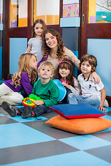 Image showing Teacher And Students Sitting On Floor In Classroom