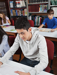 Image showing Male Student Reading Book In Library